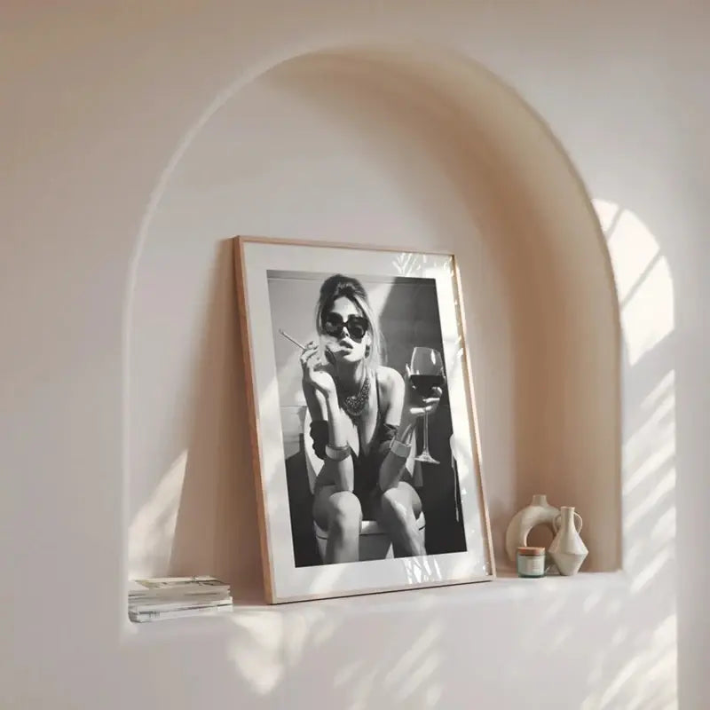 Black and white fashion art print in wooden frame, styled in arched niche for modern home decor
